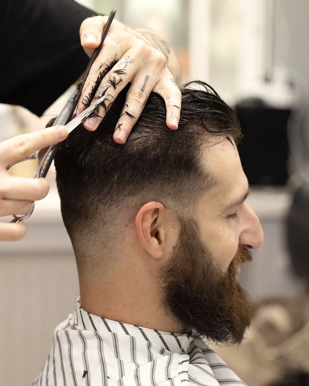 Men's haircut being tapered with shears at a Charleston, WV salon